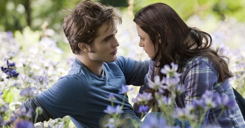 Les personnages Bella et Edward, s'enlaçant dans l'herbe.