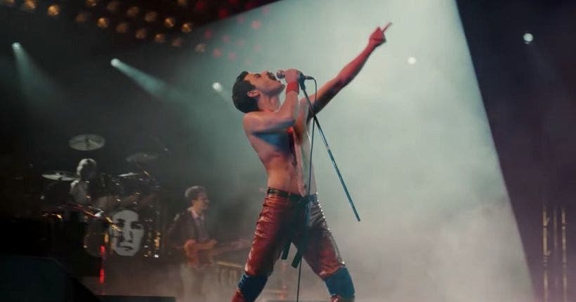 Freddie Mercury, torse nu en pleine performance de Bohemian Rhapsody, sous les feux des projecteurs.