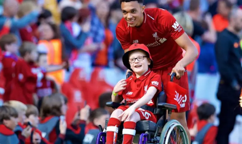 Un joueur de Liverpool emmène un fan en chaise roulante faire le tour d’honneur avec le reste de l’équipe