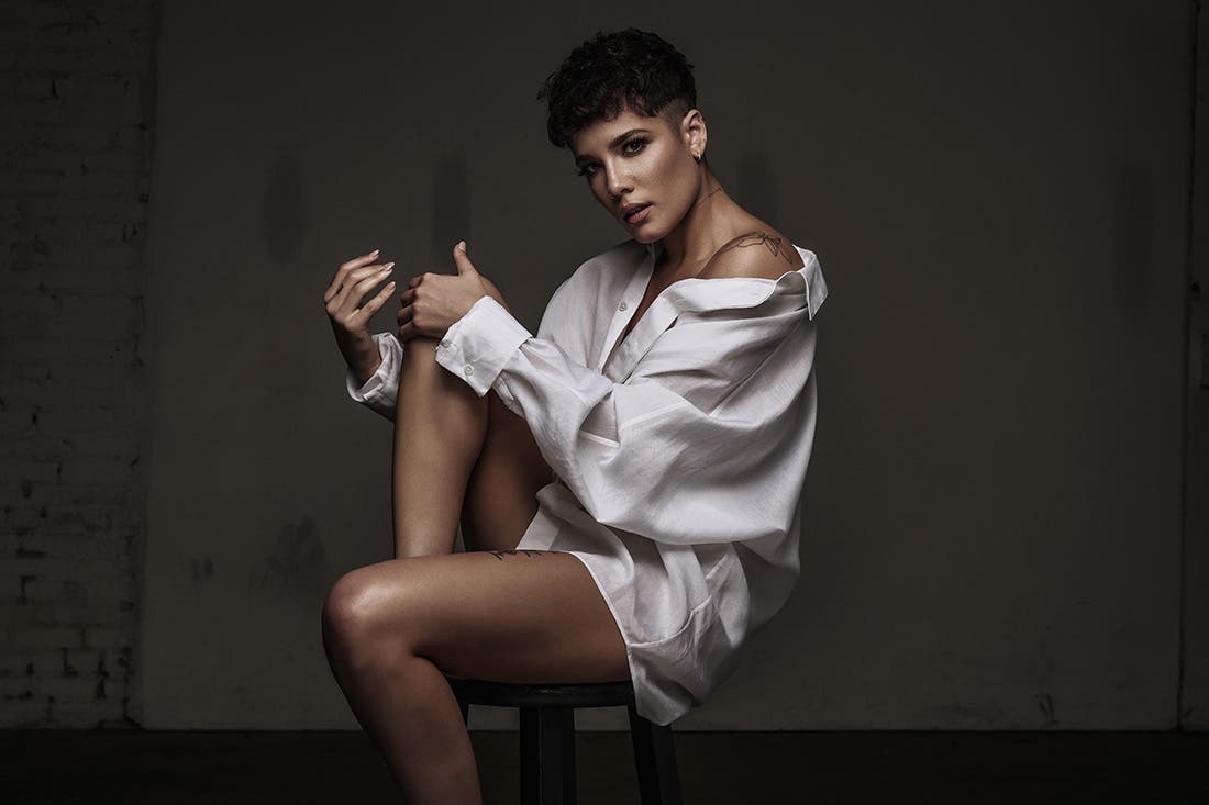 Image tirée du clip Without Me, de l'artiste Halsey, nue en chemise sur un tabouret.