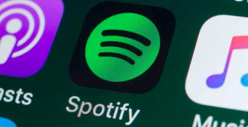 <p>London, UK &#8211; July 31, 2018: The buttons of the music streaming app Spotify, surrounded by Podcasts, Apple Music, Facebook and other apps on the screen of an iPhone.</p>
