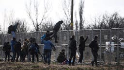 <p>A Turkish soldier stands guard behind fences erected by the Turkish army as migrants jump over it near Pazarkule border gate in Edirne on March 4, 2020, during their journey to try  to enter Europe. &#8211; Turkish officials claimed on March 4, 2020 that one migrant was killed by Greek fire on the Turkey-Greece border where thousands of migrants have massed since last week. But on the other side Greece &#8220;categorically&#8221; denied claims by Turkey that it had fired live bullets against migrants on the border, with several allegedly injured and one later dying. (Photo by Ozan KOSE / AFP)</p>
