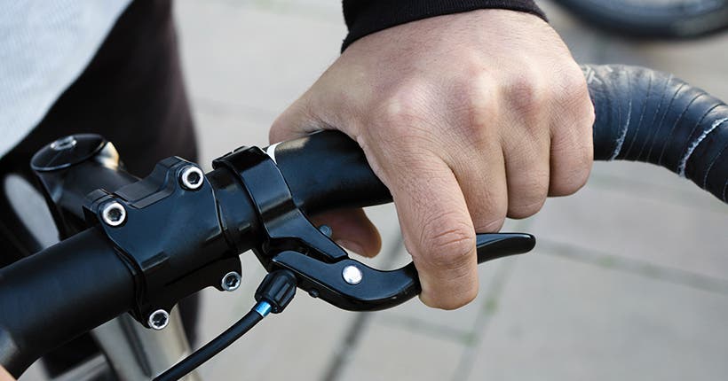 <p>Hand on bike handle and brake</p>
